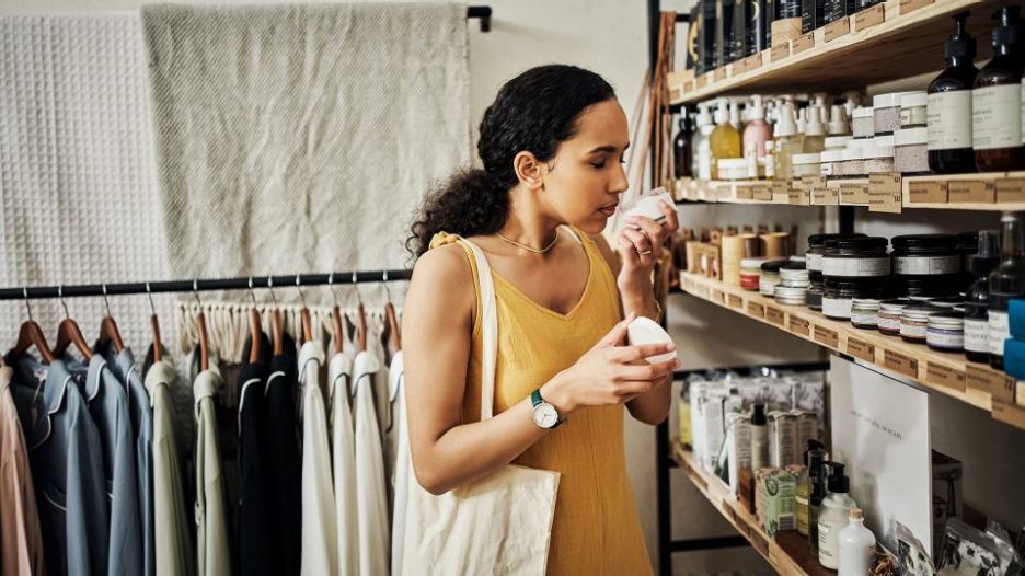a woman is smelling different soaps on offer in a store