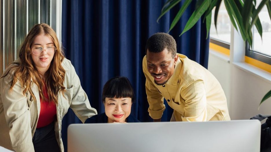 group of young people working in office using computer
